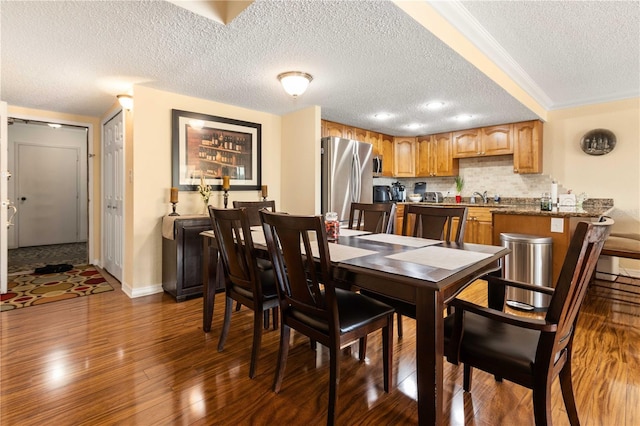 dining room featuring dark wood finished floors, a textured ceiling, and baseboards