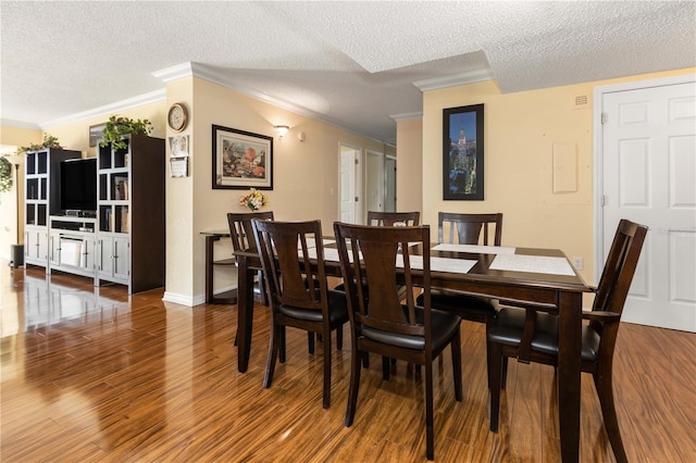 dining area featuring ornamental molding, a textured ceiling, baseboards, and wood finished floors