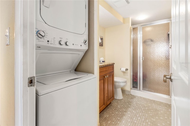 laundry area with stacked washer and dryer, laundry area, visible vents, and light tile patterned flooring