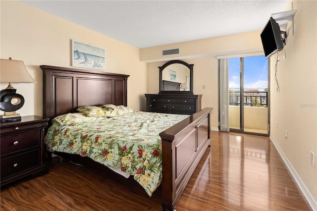 bedroom featuring access to outside, a textured ceiling, visible vents, and dark wood-type flooring