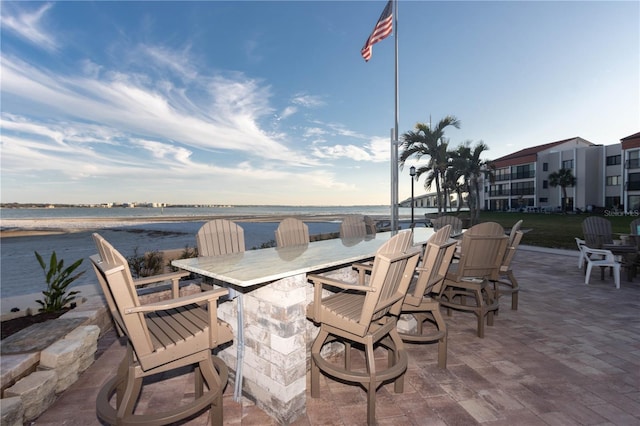 view of patio / terrace featuring a water view and outdoor dry bar