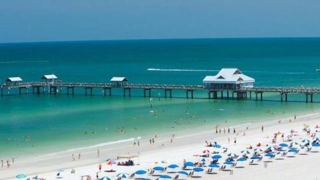 property view of water featuring a pier and a beach view