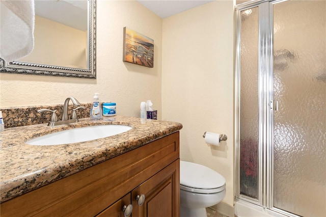 full bath with a stall shower, vanity, and toilet