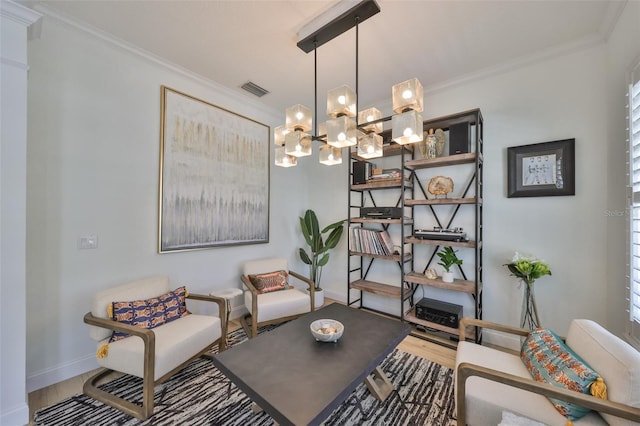 living area with baseboards, visible vents, ornamental molding, and wood finished floors