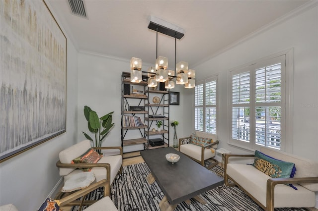 sitting room with visible vents, a chandelier, crown molding, and wood finished floors