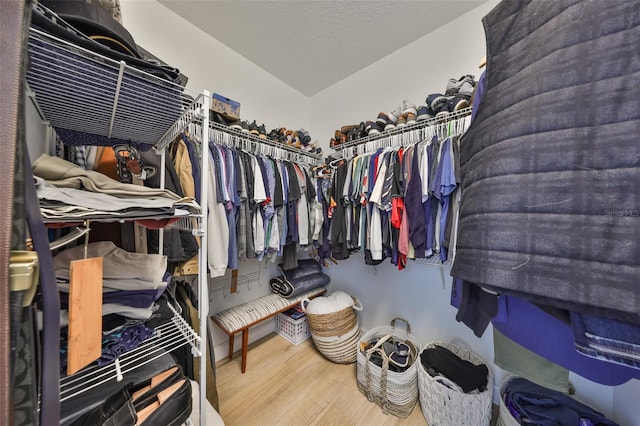 walk in closet with wood finished floors