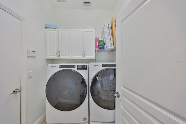 laundry room with visible vents, separate washer and dryer, and cabinet space