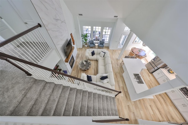 interior space featuring lofted ceiling, visible vents, wood finished floors, and a glass covered fireplace