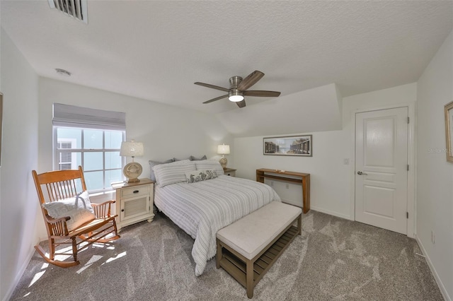 bedroom with a textured ceiling, a ceiling fan, visible vents, baseboards, and carpet