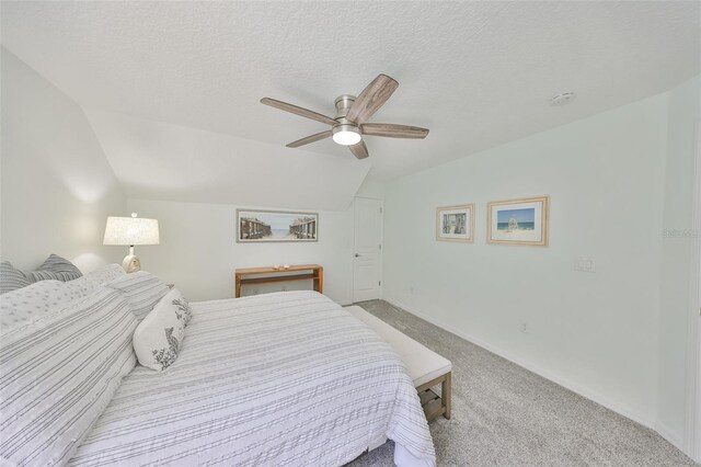 carpeted bedroom featuring lofted ceiling, baseboards, a ceiling fan, and a textured ceiling