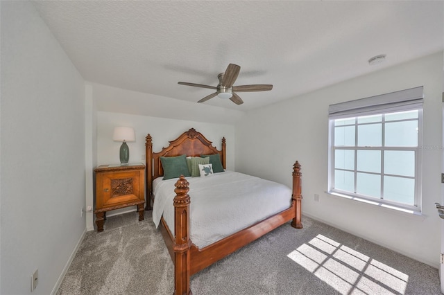 carpeted bedroom featuring a textured ceiling, baseboards, and a ceiling fan