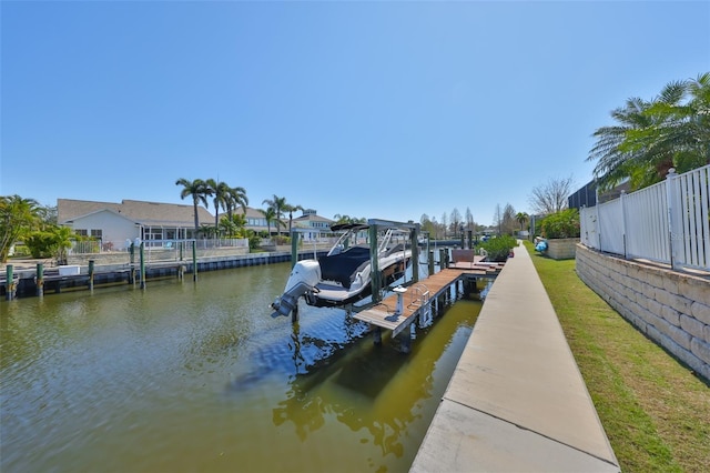 view of dock featuring a water view, boat lift, and fence