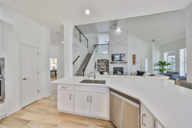 413 Islebay Dr, Apollo Beach, FL 33572 - kitchen with stainless steel dishwasher, a sink, open floor plan, white cabinets, and light countertops