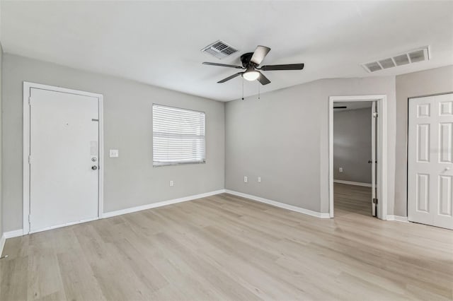 unfurnished room featuring baseboards, visible vents, and light wood finished floors