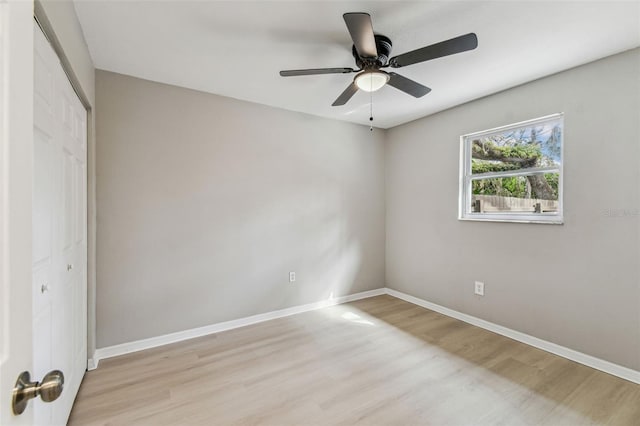 unfurnished bedroom featuring a ceiling fan, baseboards, a closet, and wood finished floors