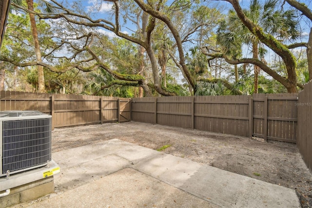 view of yard featuring a fenced backyard, a patio, and central air condition unit