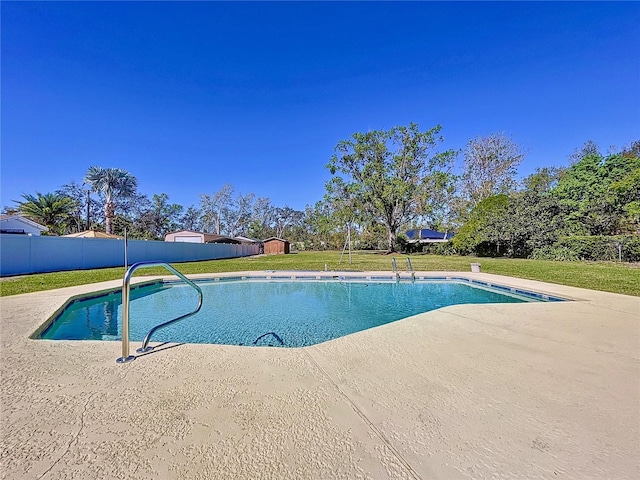 view of pool featuring a yard, a fenced in pool, and a patio area