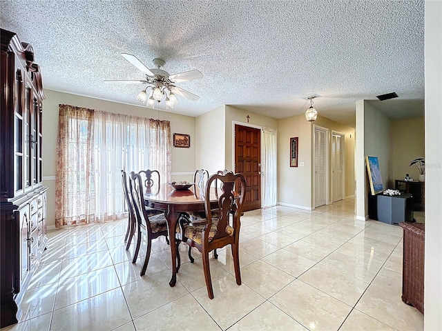 dining space with light tile patterned floors, a textured ceiling, and ceiling fan