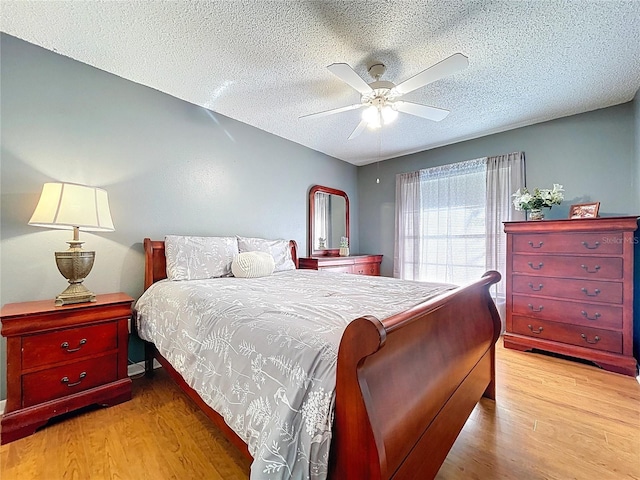 bedroom featuring a textured ceiling, a ceiling fan, and wood finished floors