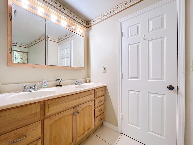 bathroom featuring tile patterned floors, baseboards, double vanity, and a sink