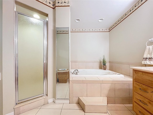 bathroom with tile patterned flooring, a stall shower, a bath, and vanity