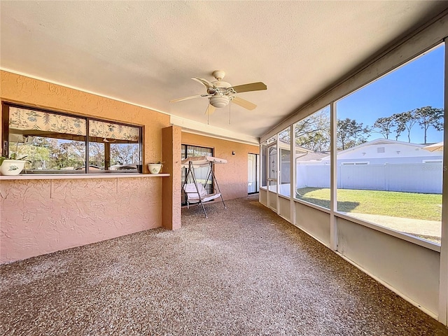 unfurnished sunroom featuring a ceiling fan