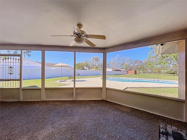 unfurnished sunroom featuring ceiling fan