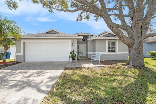 ranch-style house with a garage, brick siding, driveway, stucco siding, and a front yard