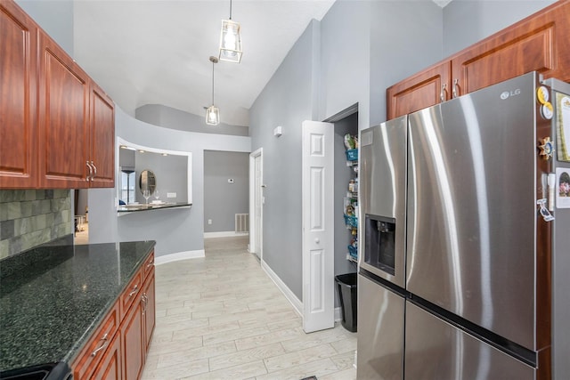 2519 Southern Oak Cir, Clearwater, FL 33764 - kitchen featuring light wood finished floors, tasteful backsplash, lofted ceiling, dark stone countertops, and stainless steel fridge
