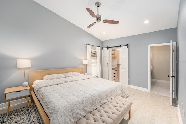 2519 Southern Oak Cir, Clearwater, FL 33764 - bedroom featuring vaulted ceiling, a barn door, baseboards, and light wood-style floors