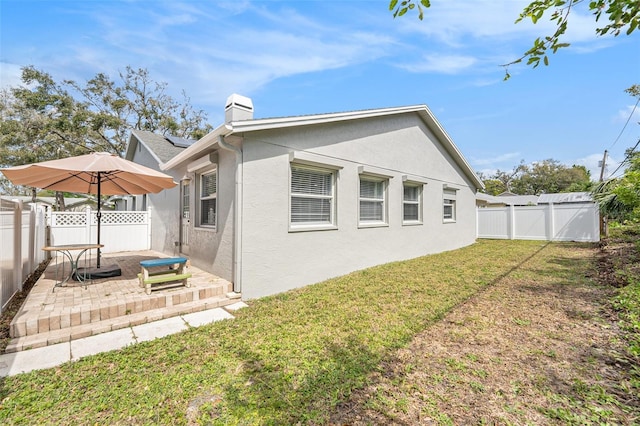 2519 Southern Oak Cir, Clearwater, FL 33764 - back of house with a yard, a fenced backyard, a patio, and stucco siding