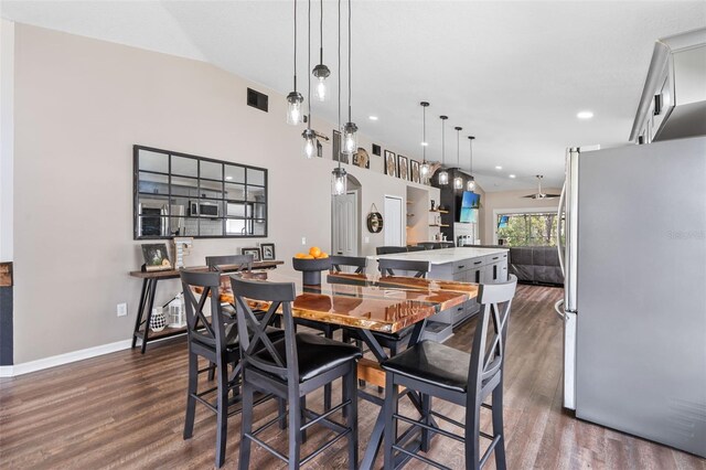 31123 Stone Arch Ave, Wesley Chapel, FL 33545 - dining space featuring lofted ceiling, dark wood-style floors, visible vents, and baseboards