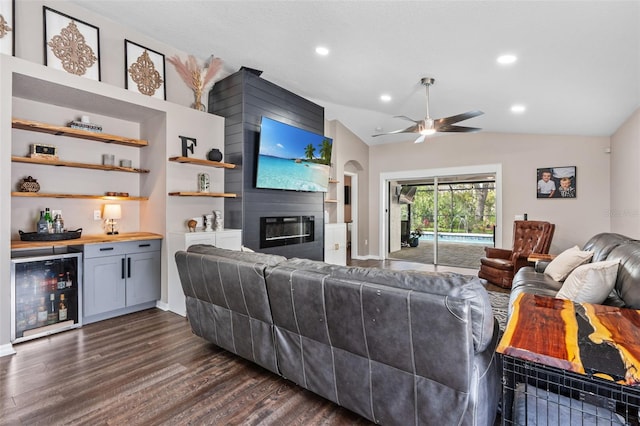31123 Stone Arch Ave, Wesley Chapel, FL 33545 - living area featuring lofted ceiling, wine cooler, a large fireplace, dark wood-style floors, and a dry bar