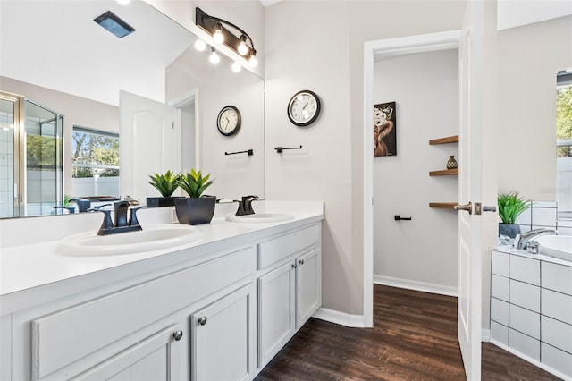 31123 Stone Arch Ave, Wesley Chapel, FL 33545 - full bathroom featuring double vanity, a garden tub, a sink, and wood finished floors