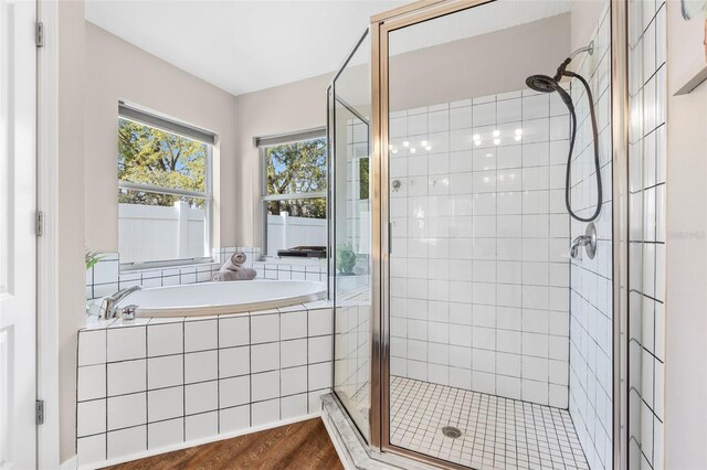 31123 Stone Arch Ave, Wesley Chapel, FL 33545 - full bath featuring a garden tub, a shower stall, and wood finished floors