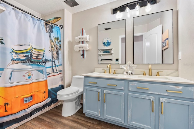 31123 Stone Arch Ave, Wesley Chapel, FL 33545 - full bathroom featuring double vanity, visible vents, a sink, and wood finished floors