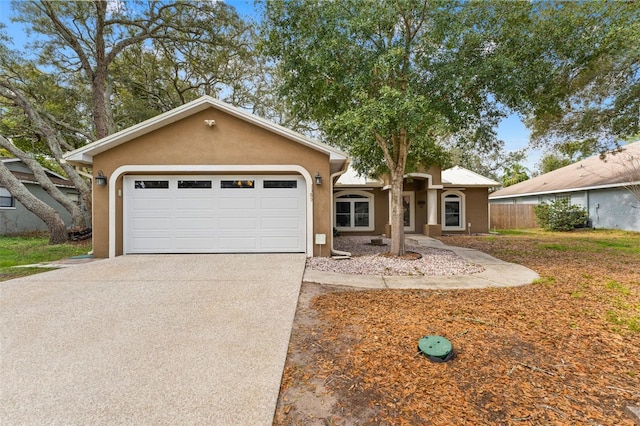 ranch-style home featuring stucco siding, driveway, and a garage