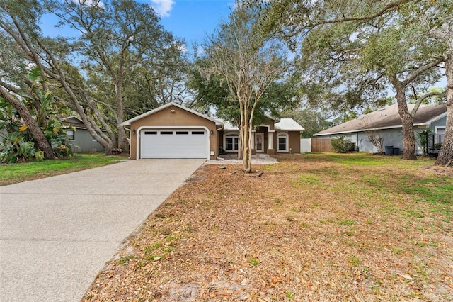 single story home with stucco siding, a front lawn, driveway, fence, and a garage