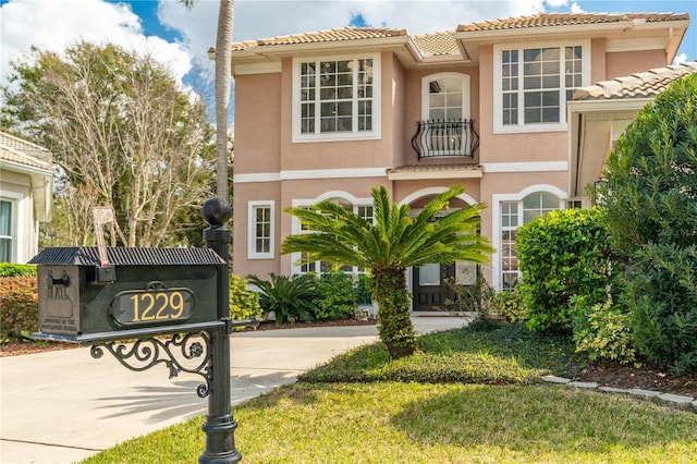 mediterranean / spanish-style house with driveway, a tiled roof, and stucco siding