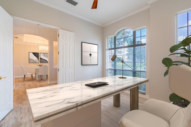 home office featuring arched walkways, visible vents, light wood-style flooring, ornamental molding, and a ceiling fan