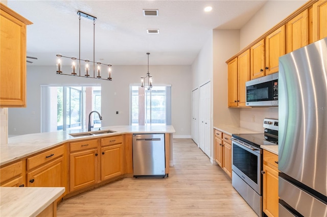 kitchen with light countertops, appliances with stainless steel finishes, a sink, and visible vents