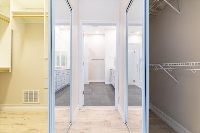 spacious closet with light wood-style floors and visible vents