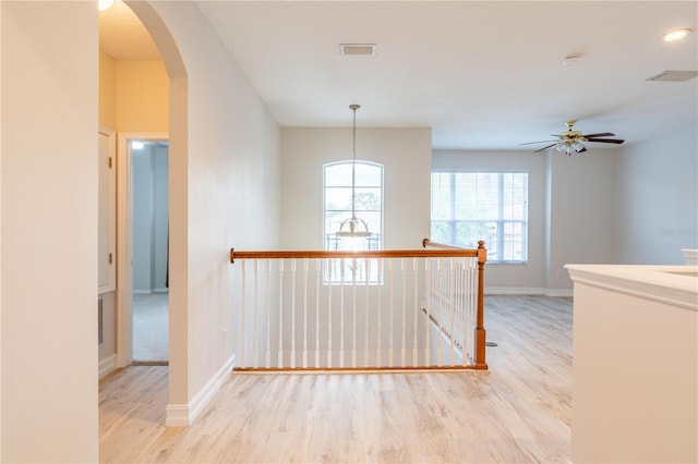 hallway featuring visible vents, arched walkways, and wood finished floors