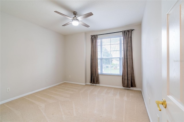 carpeted empty room featuring ceiling fan and baseboards