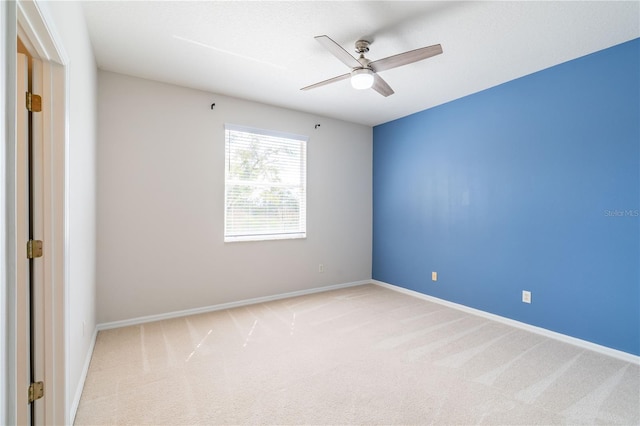 spare room featuring carpet floors, baseboards, and a ceiling fan