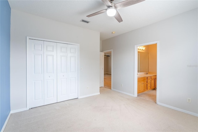 unfurnished bedroom featuring a closet, visible vents, ensuite bathroom, light carpet, and baseboards