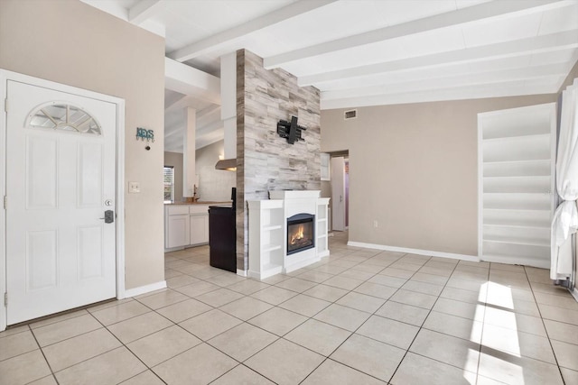 unfurnished living room with vaulted ceiling with beams, light tile patterned floors, a fireplace, and baseboards