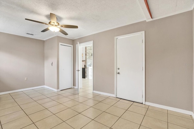 unfurnished room with light tile patterned floors, visible vents, ceiling fan, a textured ceiling, and baseboards