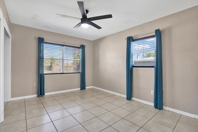 spare room featuring ceiling fan, baseboards, and light tile patterned flooring