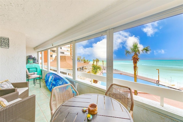 sunroom featuring a water view